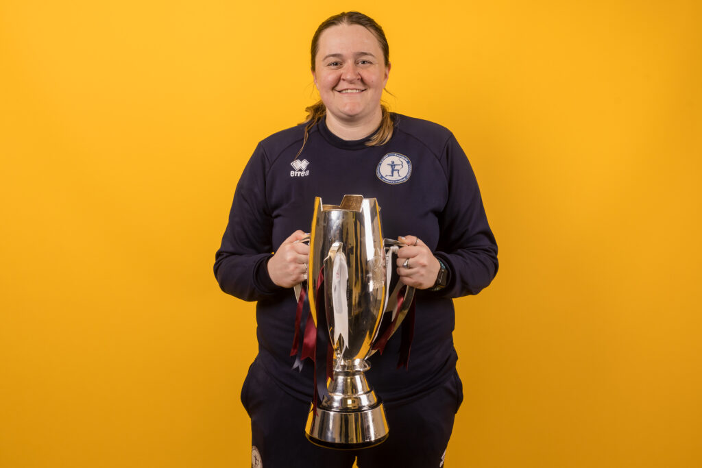 Cardiff Met's manager Yzzy Taylor celebrate with the trophy during the 2022/23 Genero Adran Trophy Final  between Cardiff Met Women FC & Cardiff City Women FC at the SDM Glass Stadium, Bridgend, Wales, 12th March 2023.