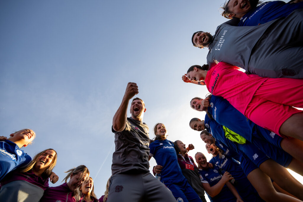 Iain Darbyshire celebrates with the Cardiff City Women squad.