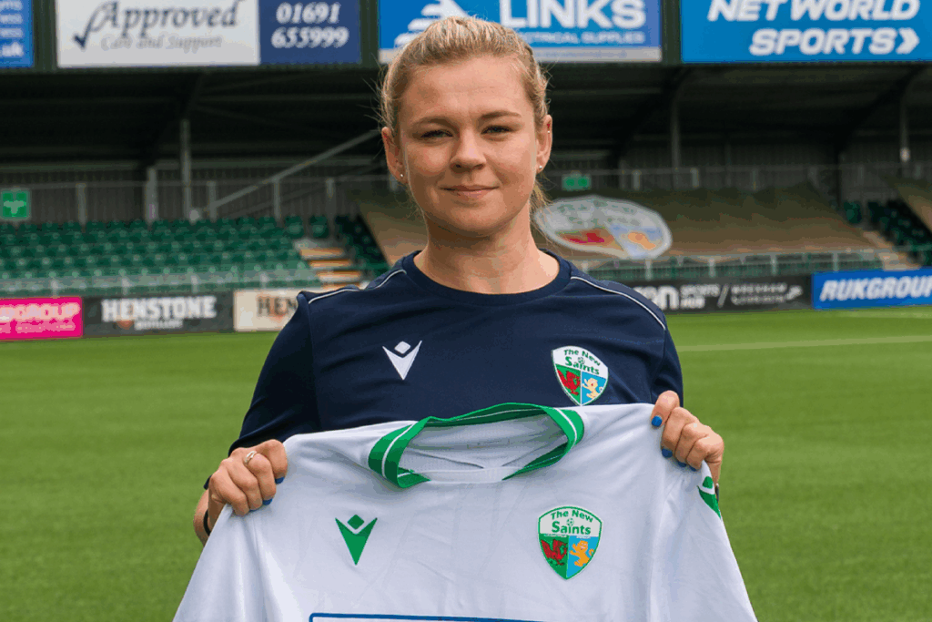 Jodie Williams holds up a New Saints shirt after being unveiled as manager. 